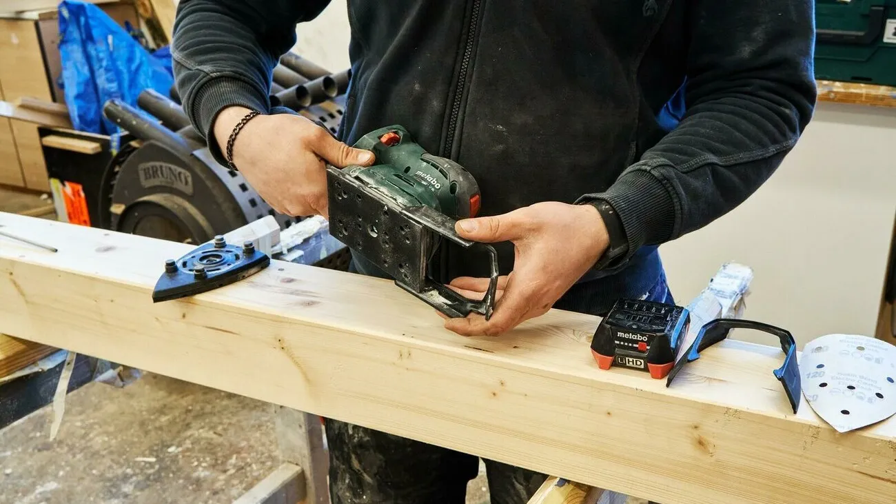 Handwerker schiebt den Protektur zum Schutz umliegender Kanten auf.
